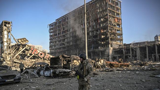 A Ukrainian serviceman walks between debris of Retroville shopping mall and residential district after a Russian attack in Kyiv on March 21. Picture: AFP.