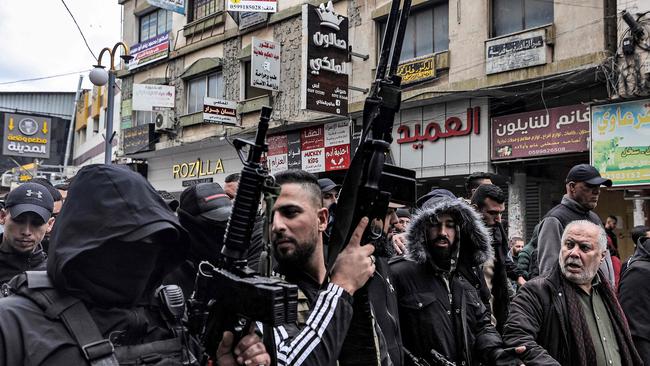 Gunmen march with mourners carrying the bodies of two of three Palestinian men who were killed in raid on Jenin’s Ibn Sina hospital. Picture: AFP