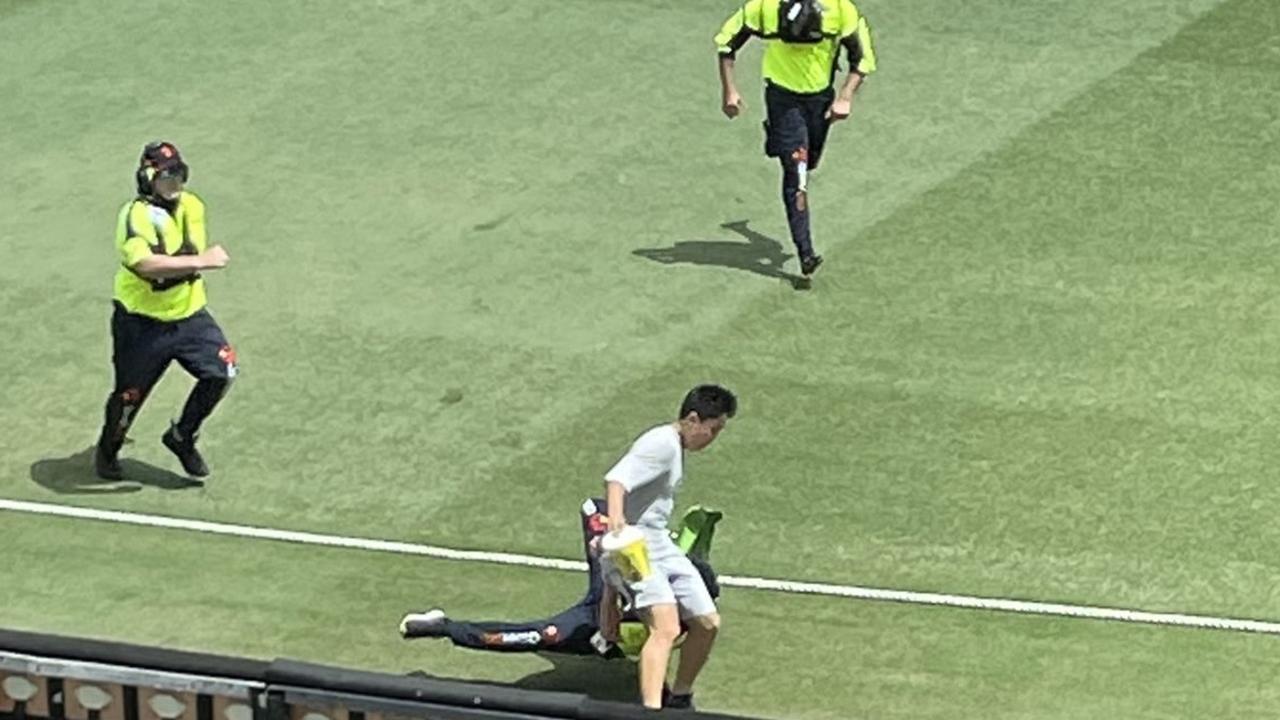 A streaker is snatched by security on the Gabba. Photo: Twitter, @Sportsbetcomau.