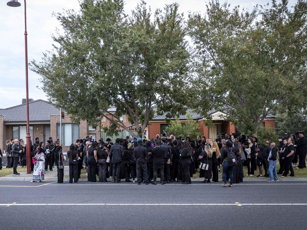 Mourners dressed in black gather at the bus stop where Nathan was killed. Picture: Jake Nowakowski