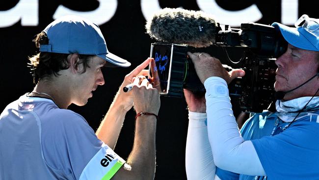 Australia's Alex De Minaur signs his autograph on a camera after beating France's Benjamin Bonzi. Picture: AFP