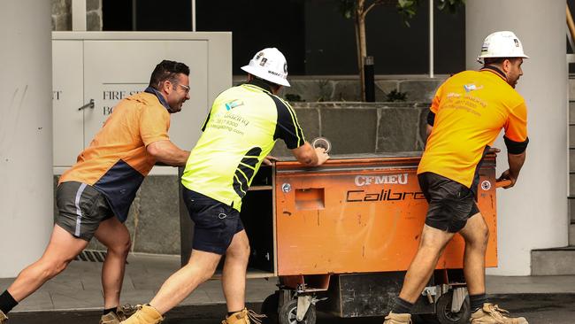 Workers leave the Probuild worksite on 443 Queens Street on Wednesday. Picture: Zak Simmonds