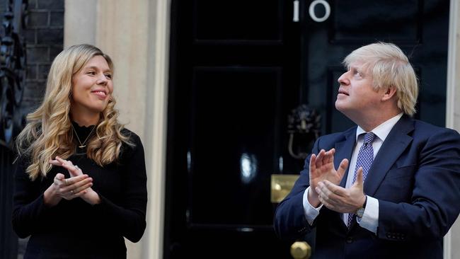 Britain's Prime Minister Boris Johnson (R) and his fiancee Carrie Symonds participate in a national "clap for carers" to show thanks for the work of Britain's NHS (National Health Service) workers in May, 2020. Picture: Andrew Parsons/10 Downing Street/AFP)