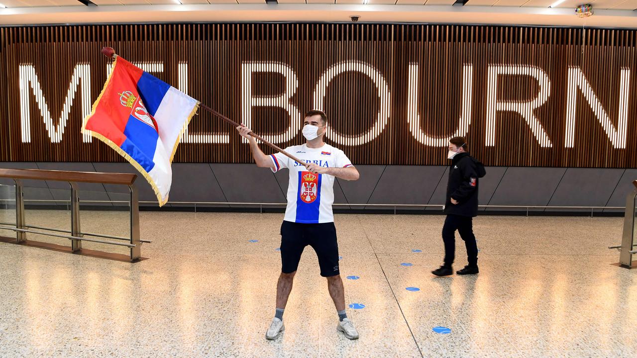 A Serbian tennis fan waves a flag as he awaits the arrival of Serbia's tennis champion Novak Djokovic in Melbourne.