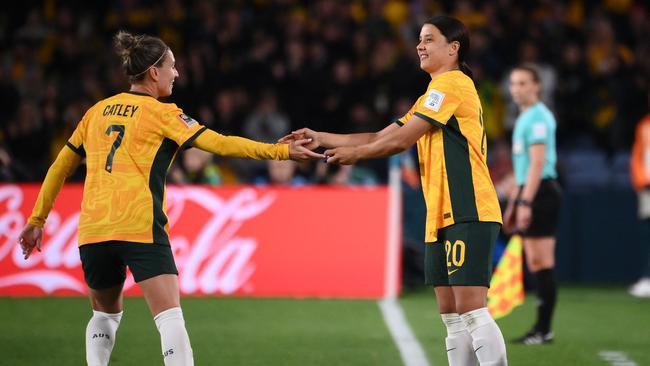 Sam Kerr (R) is greeted by captain Steph Catley (L) as she enters the field. Picture: AFP