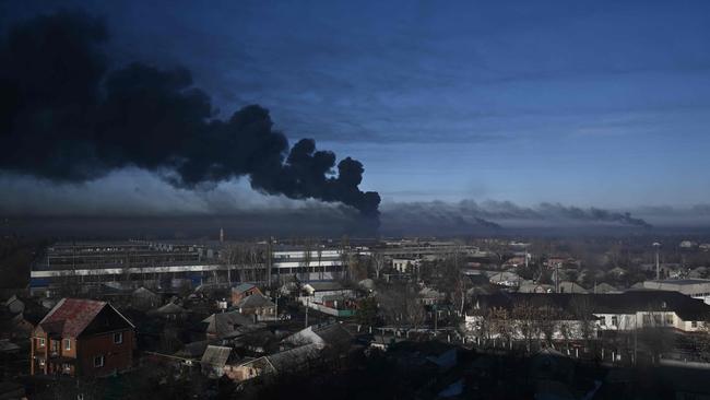 Black smoke rises from a military airport in Chuguyev near Kharkiv. (Photo by Aris Messinis / AFP)