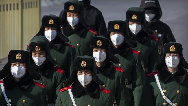 Paramilitary policemen wear face masks as they march in formation into a pedestrian underpass next to Tiananmen Square in Beijing.