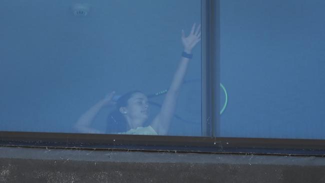 A tennis player under quarantine goes through her serve motion in her hotel room in Melbourne ahead of the Australian Open. Picture: AFP