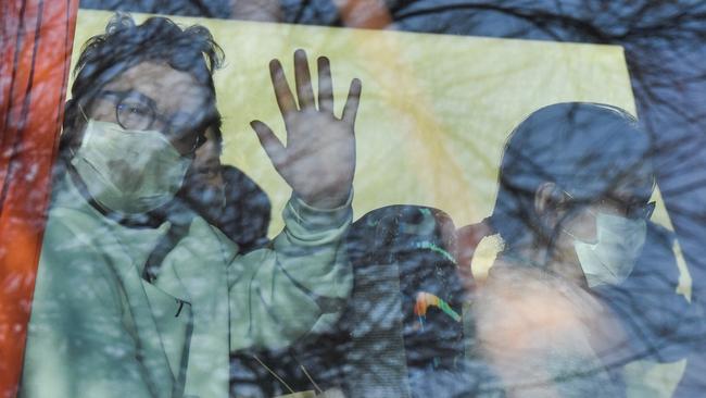 A passenger waves from a vehicle believed to contain French citizens after their evacuation from the Chinese city of Wuhan, as it arrives in Carry-le-Rouet, near Marseilles, on January 31. Picture: AFP