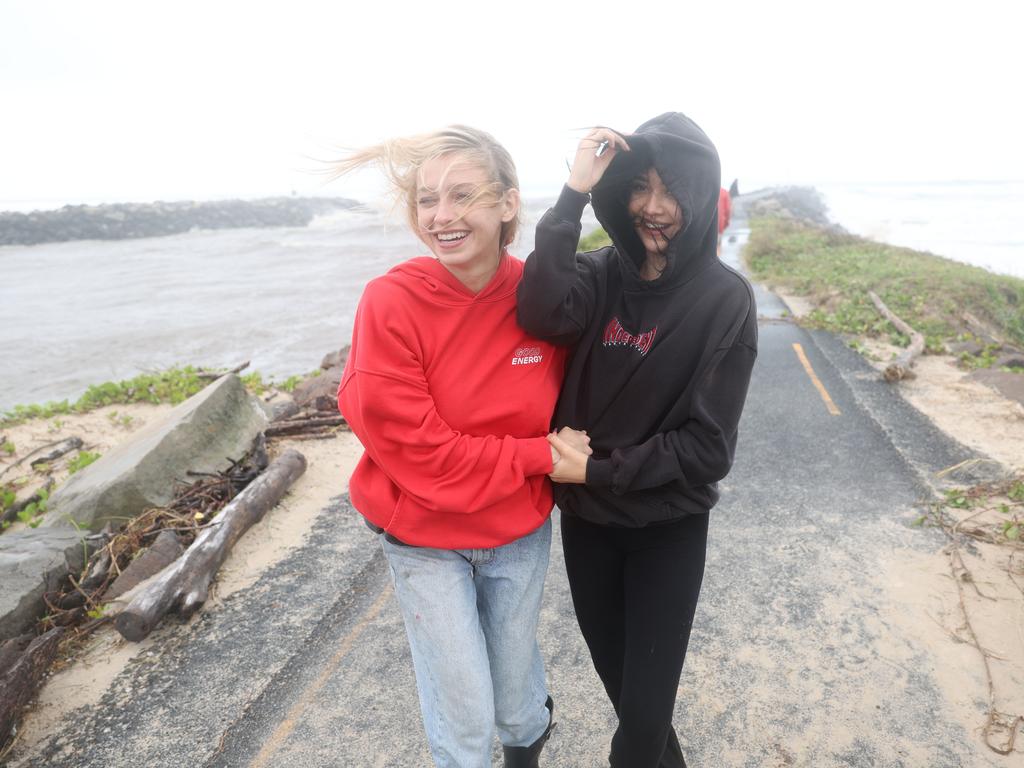 Grace Mulholland and Sanji Clarkson at the break wall to see the erosion on the beach and the big swells. Picture: Rohan Kelly