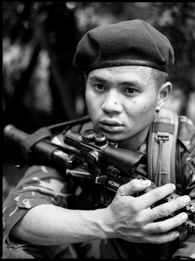 Paul Du, 19, a rebel fighter with the Karenni Nationalities Defense Force rests under a tree on the frontline in Yangon, Myanmar.