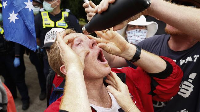 A protester has capsicum spray washed from his eyes during an anti-lockdown protest in Melbourne on Friday. Picture: NCA NewsWire / Daniel Pockett