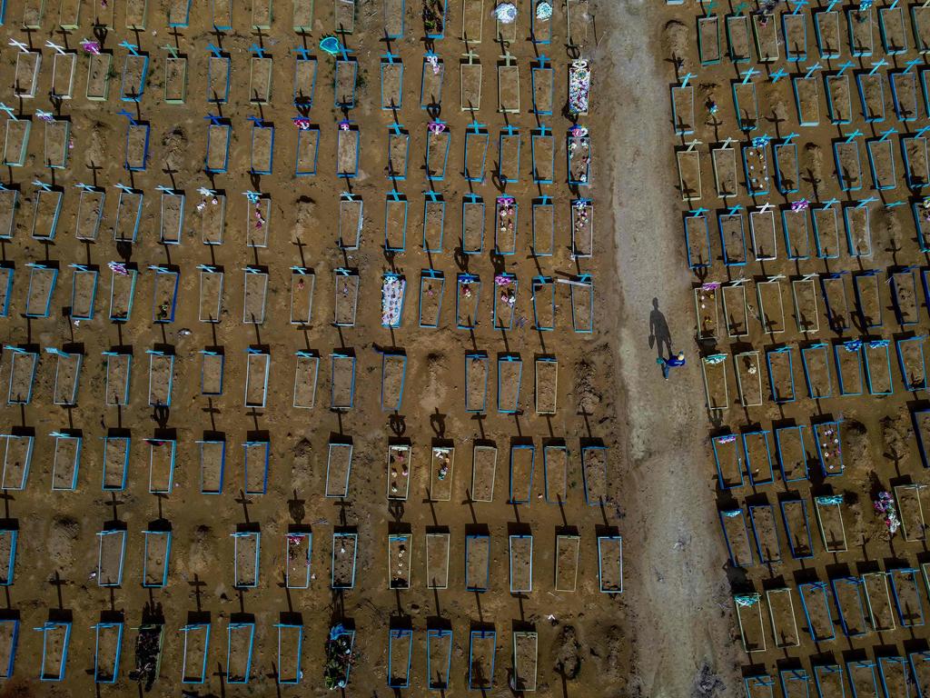 A gravedigger walks among graves at the Nossa Senhora Aparecida cemetery in Manaus, Brazil. Picture: Michael Dantas/AFP