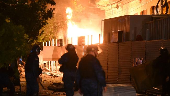 Policemen are seen near a fire set by demonstrators at the Commerce Ministry headquarters during a protest against corruption and cracks in the health system, demanding the resignation of Paraguayan President Mario Abdo Benitez, in Asuncion. Picture: Norberto Duarte/AFP