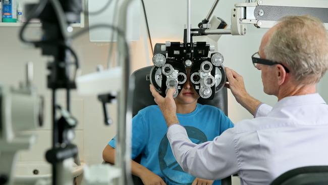 Optometrist Trevor Scott conducts an eyesight test on a child. Picture: Troy Snook