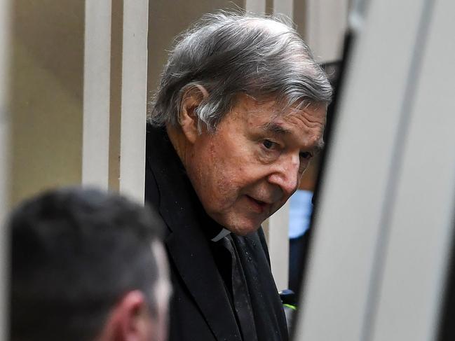 Australian Cardinal George Pell (C) is escorted in handcuffs from the Supreme Court of Victoria in Melbourne on August 21, 2019. - Disgraced Catholic Cardinal George Pell was sent back to jail after an Australian court rejected his landmark appeal against convictions for child sex abuse. (Photo by William WEST / AFP)