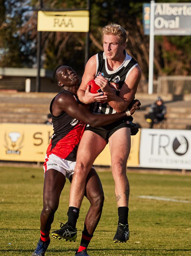 Port's Billy Frampton takes a grab in front of West's Chol Majok at Alberton Oval. Picture: MATT LOXTON