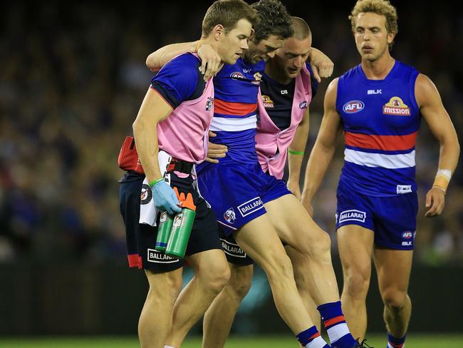 Murphy is helped off the ground. Picture:Wayne Ludbey
