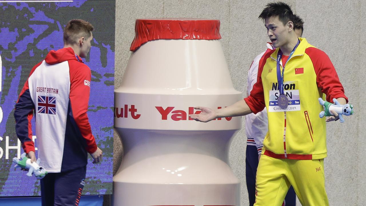 Sun Yang gestures to Britain's bronze medallist Duncan Scott.
