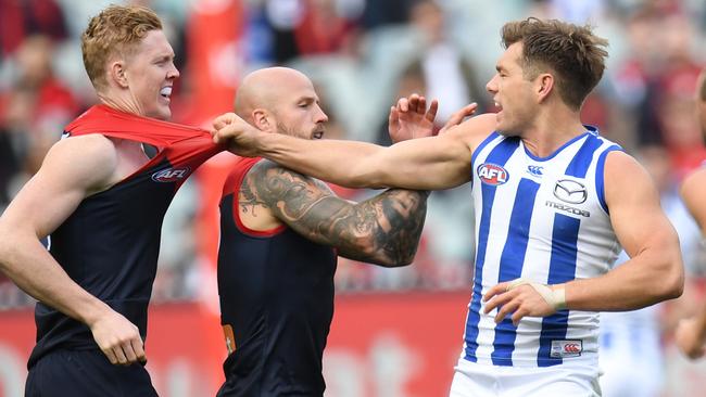 Shaun Higgins and Clayton Oliver clash during the at time spiteful game at the MCG.