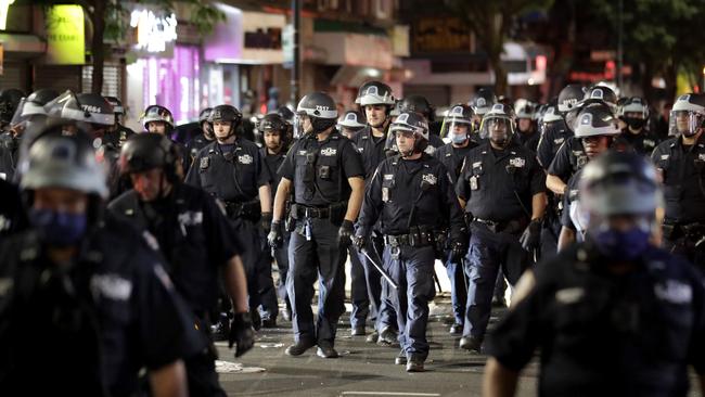 Police in riot gear walk down a street during a protest in Brooklyn. Picture: AFP