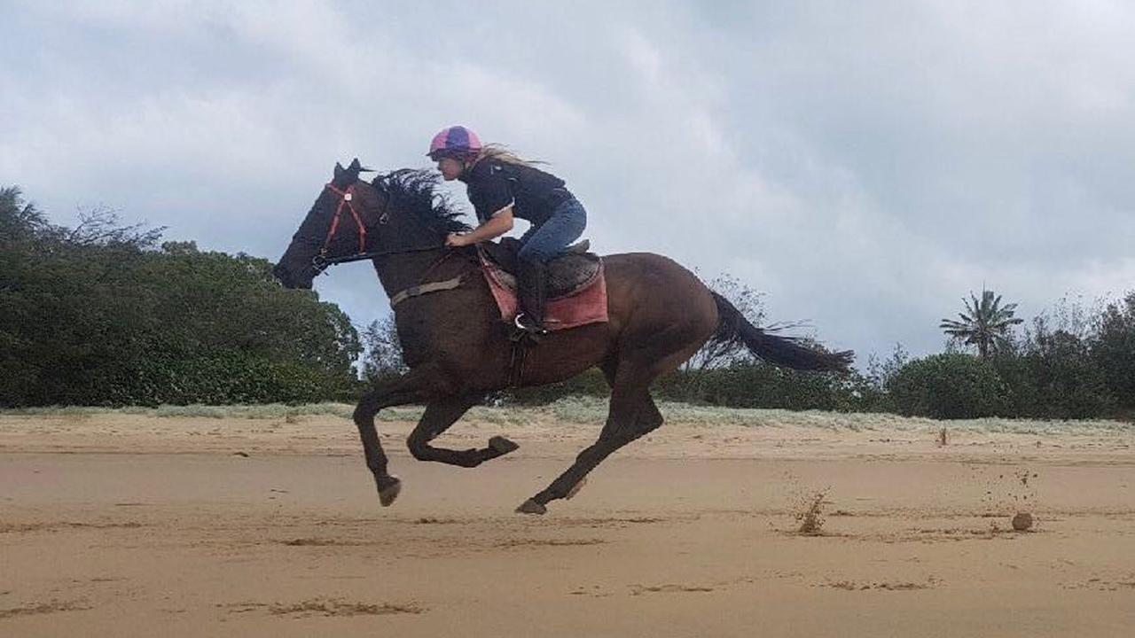 Mackay-based trainer Trinity Bannon rides Grand Emporer on the beach.