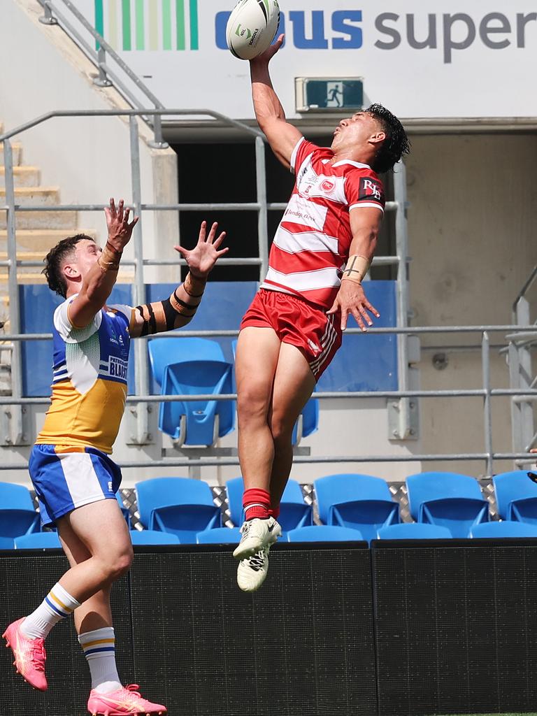 NRL National Schoolboys Cup final at CBUS Stadium between Palm Beach Currumbin and Patrician Blacktown Brothers. Palm Beach Currumbin's Sunny Kama leaps high over a Patrician Blacktown Brothers player. .Picture Glenn Hampson