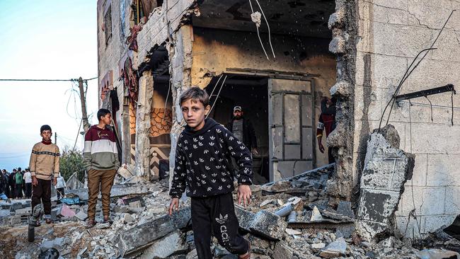 People walk through the rubble of a building heavily damaged by Israeli bombardment, in Rafah in the southern Gaza Strip on February 11, 2024, amid the ongoing conflict between Israel and the Palestinian militant group Hamas. Picture: Said Khatib/AFP