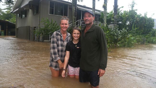 Mossman St residents Brenda, Mick and Indi Burford in front of their flooded house in Mossman. Picture Peter Carruthers