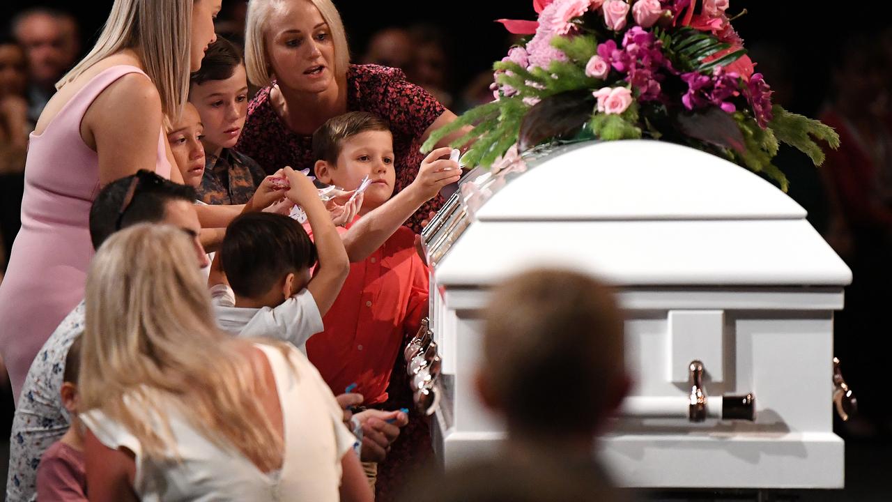 Friends Nikki Brookes and Lou Farmer help children place butterfly stickers on the coffin for Hannah Clarke and her three children. Picture: Dan Peled.