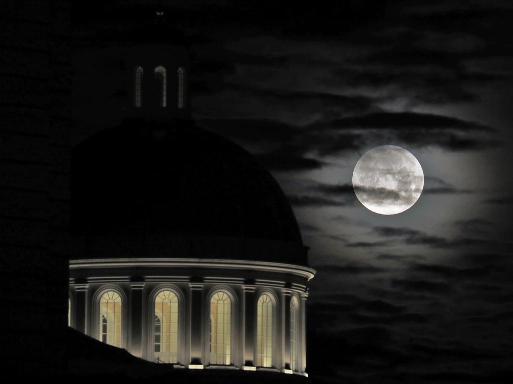 The moon begins to set over Christopher Newport Hall in Newport News, Va., early Wednesday, Jan. 31, 2018. The super blue blood moon was visible for the first time in nearly 152 years. NASA refers to the super blue blood moon as a trio of lunar events all occurring at once: the second full moon in one calendar month (a blue moon), at its closest orbital approach to Earth (a supermoon) during a lunar eclipse (a blood moon). Picture: AP