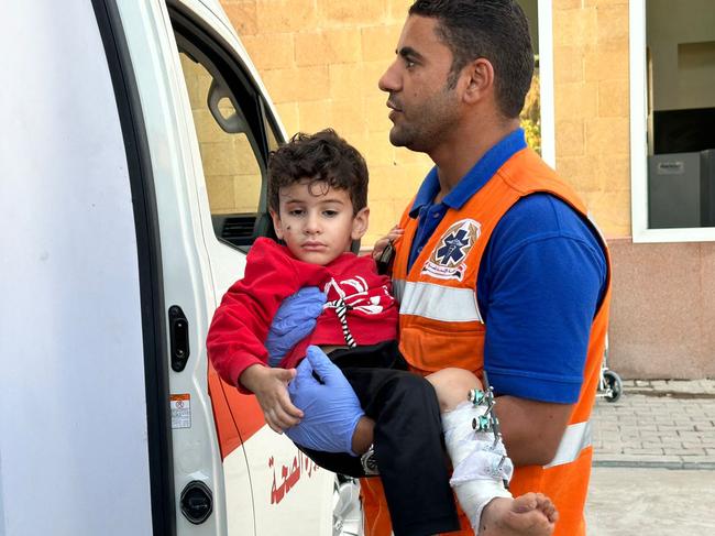 An Egyptian paramedic transfers an injured Palestinian boy arriving on the Egyptian side of the Rafah border crossing with the Gaza Strip. Picture: AFP