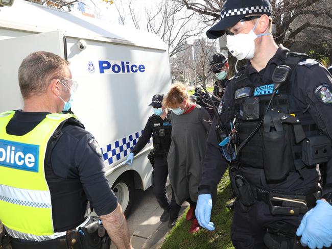 Police arrest a woman at a recent anti-mask protest in Melbourne. Picture: David Crosling