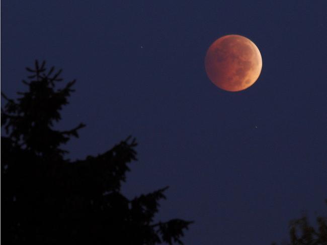 A lunar eclipse appears above Erie, Pennsylvania at about 6:45 a.m. on Wednesday morning, Oct. 8, 2014. Picture: AP