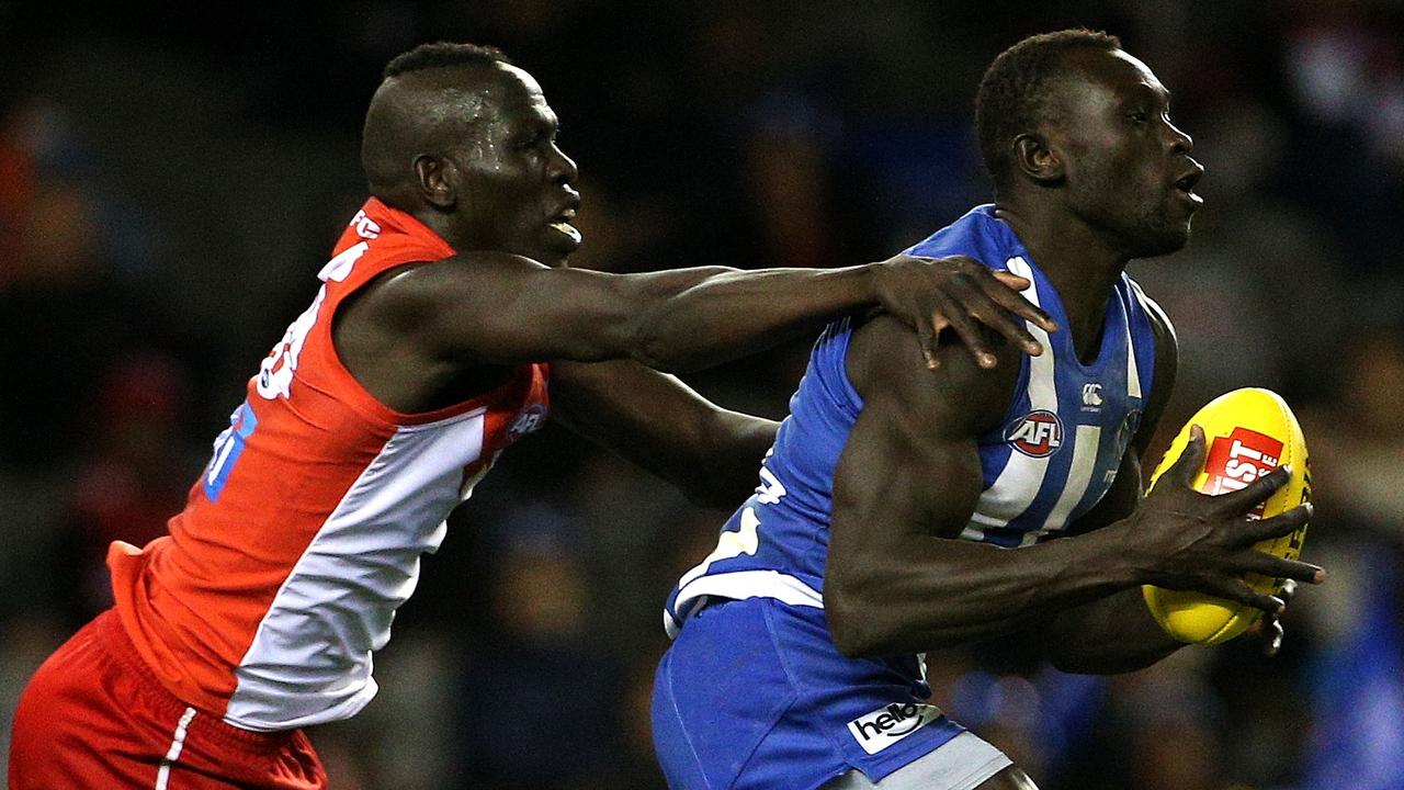 Majak Daw of the Kangaroos (right) marks in front of Aliir Aliir of the Swans.