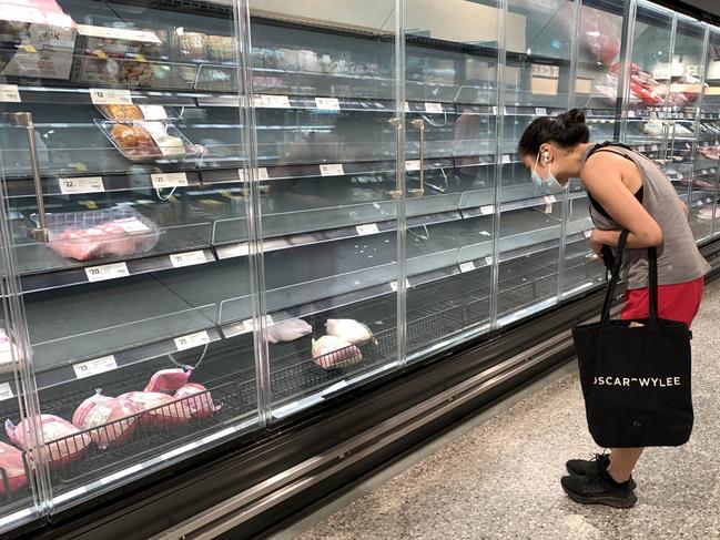 A customer looks into the empty meat section of the Coles in St Kilda. Picture: Aaron Francis