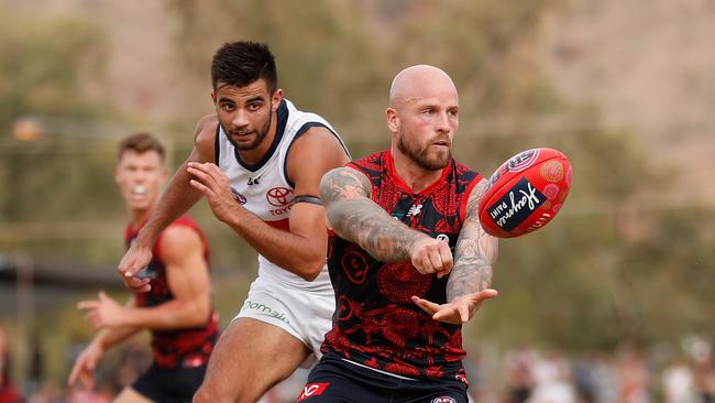 Melbourne’s Nathan Jones fires off a handball in front of Adelaide’s Wayne Milera during Sunday’s thrashing in Alice Springs. Picture: Michael Willson/AFL Media/Getty Images