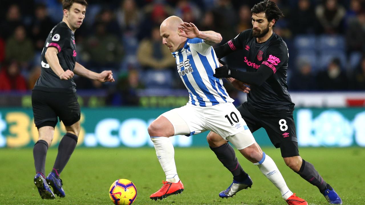 Aaron Mooy of Huddersfield Town is challenged by Andre Gomes of Everton