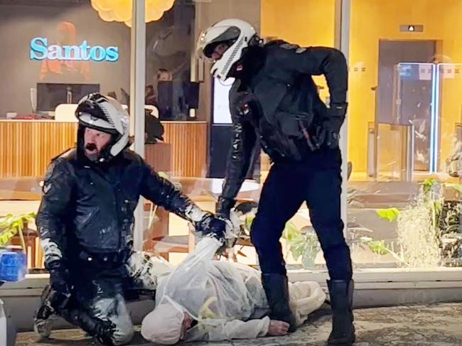 Police restrain an Extinction Rebellion protester outside the Santos building in May. Picture: Supplied