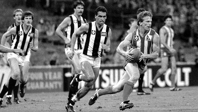 North Melbourne's Matthew Larkin breaks away from Mark Williams in the first Friday night game at the MCG in 1985.