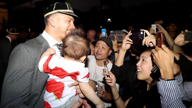 Sonny Bill Williams of the All Blacks poses with a baby at Zojoji Temple in Tokyo.