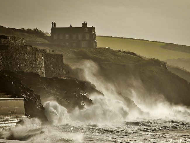 Waves crash onto the cliffs surrounding Porthleven, Cornwall, southwest England.