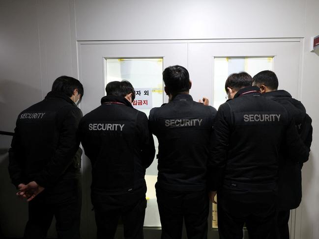 Airport security staff block the front door of the operations department during a police raid at Muan International Airport in Muan. Picture: Yonhap