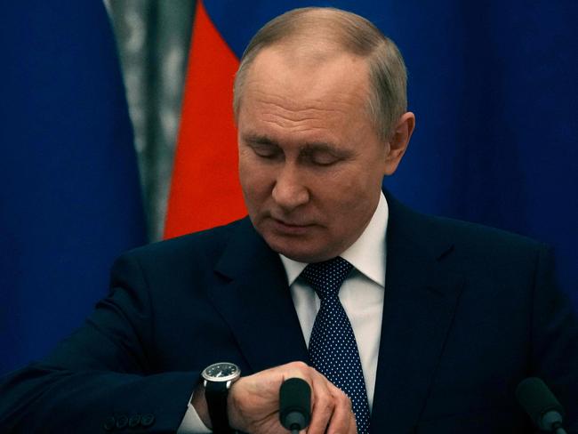 Russian President Vladimir Putin checks his watch before a press conference with the French President in Moscow. Picture: AFP