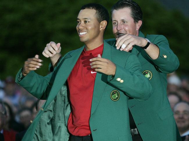 Tiger Woods receives his green jacket from Phil Mickelson after winning in 2005.