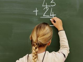 Rear view of girl writing mathematics on chalkboard (10-11)