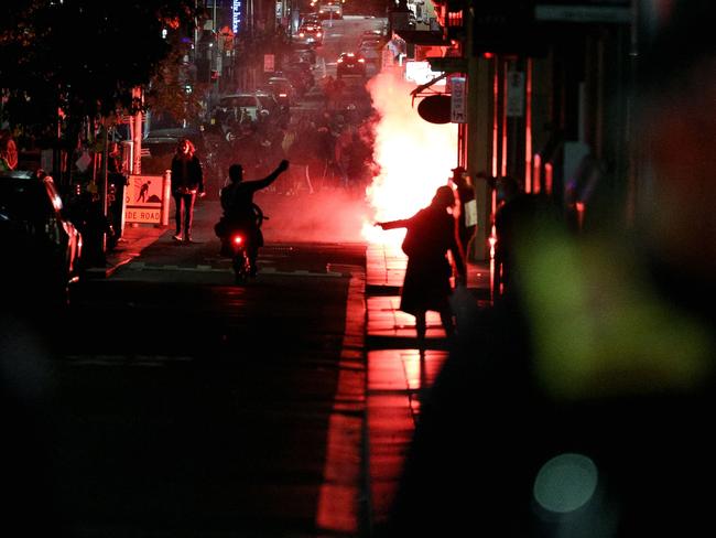 A flare is lit during an anti-lockdown protest in Melbourne on August 5 as authorities announced a sixth lockdown for the city to quash the Delta outbreak. Picture: CON CHRONIS / AFP.