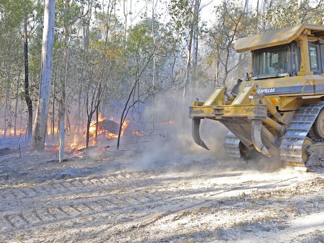 A bulldozer hurries to reinforce containment lines of an out-of-control bushfire at Whiteman Creek west of Grafton earlier this year.