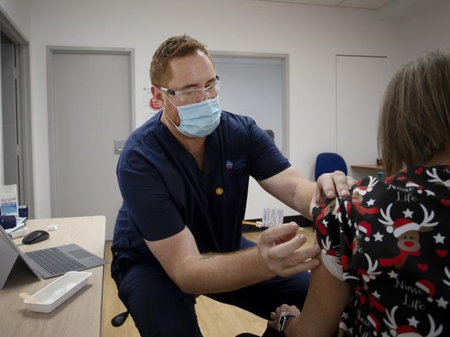 Registered nurse Kurtis Waho, administers a Pfizer vaccine booster to a client in Sydney. Picture: Lisa Maree Williams/Getty Images