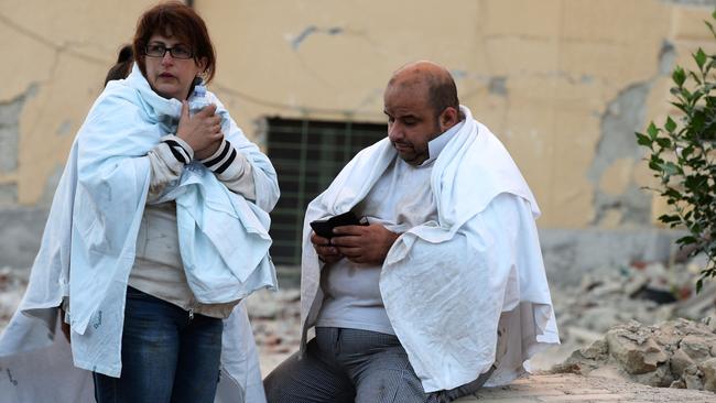 Victims react among the rubble of a house after a strong earthquake hit Amatrice. Picture: Filippo Monteforte.